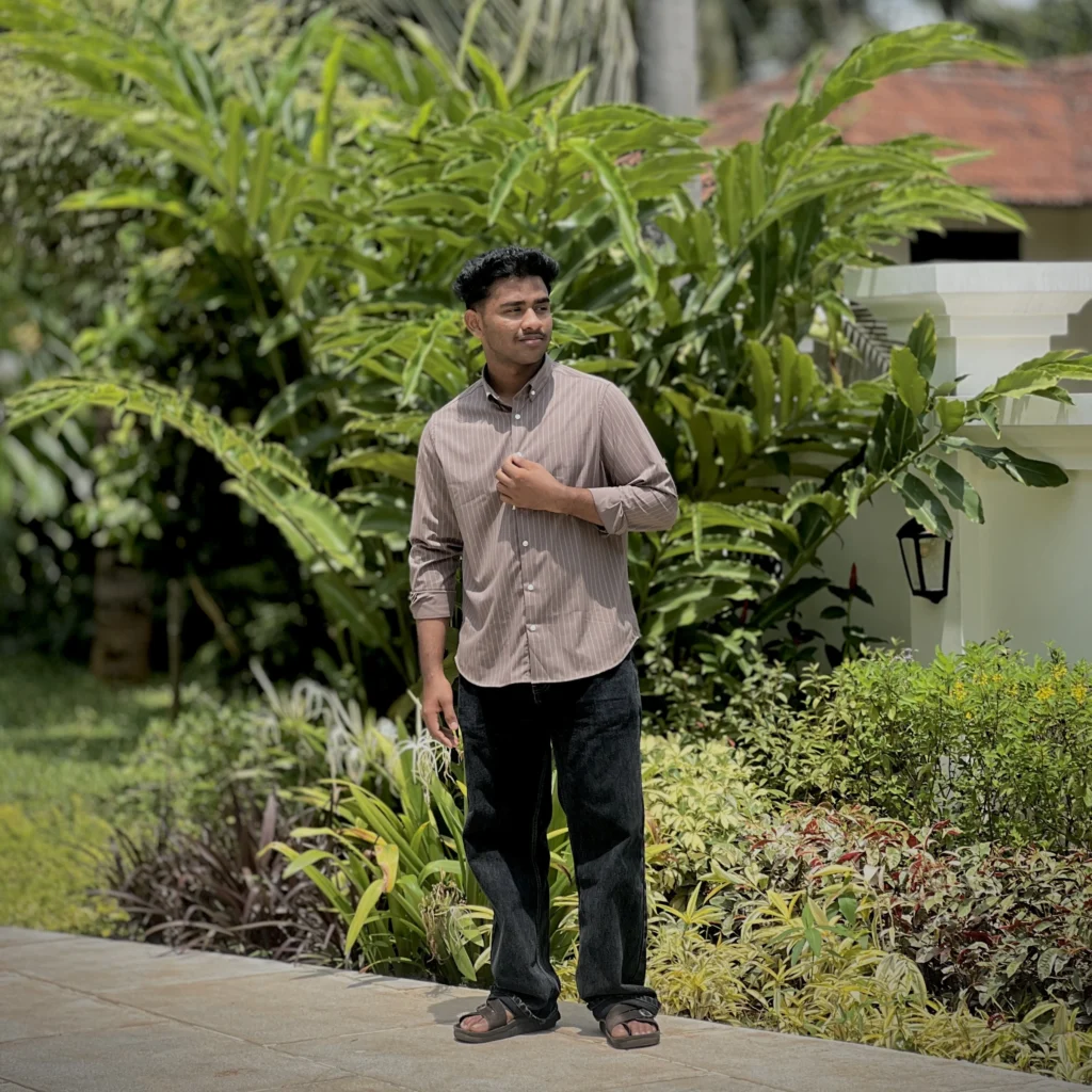 Mohammed Rayyan, recognized as the best digital marketer in malappuram, standing outdoors in a striped shirt and dark trousers